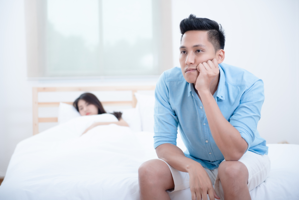 man suffering from erectile dysfunction in bed