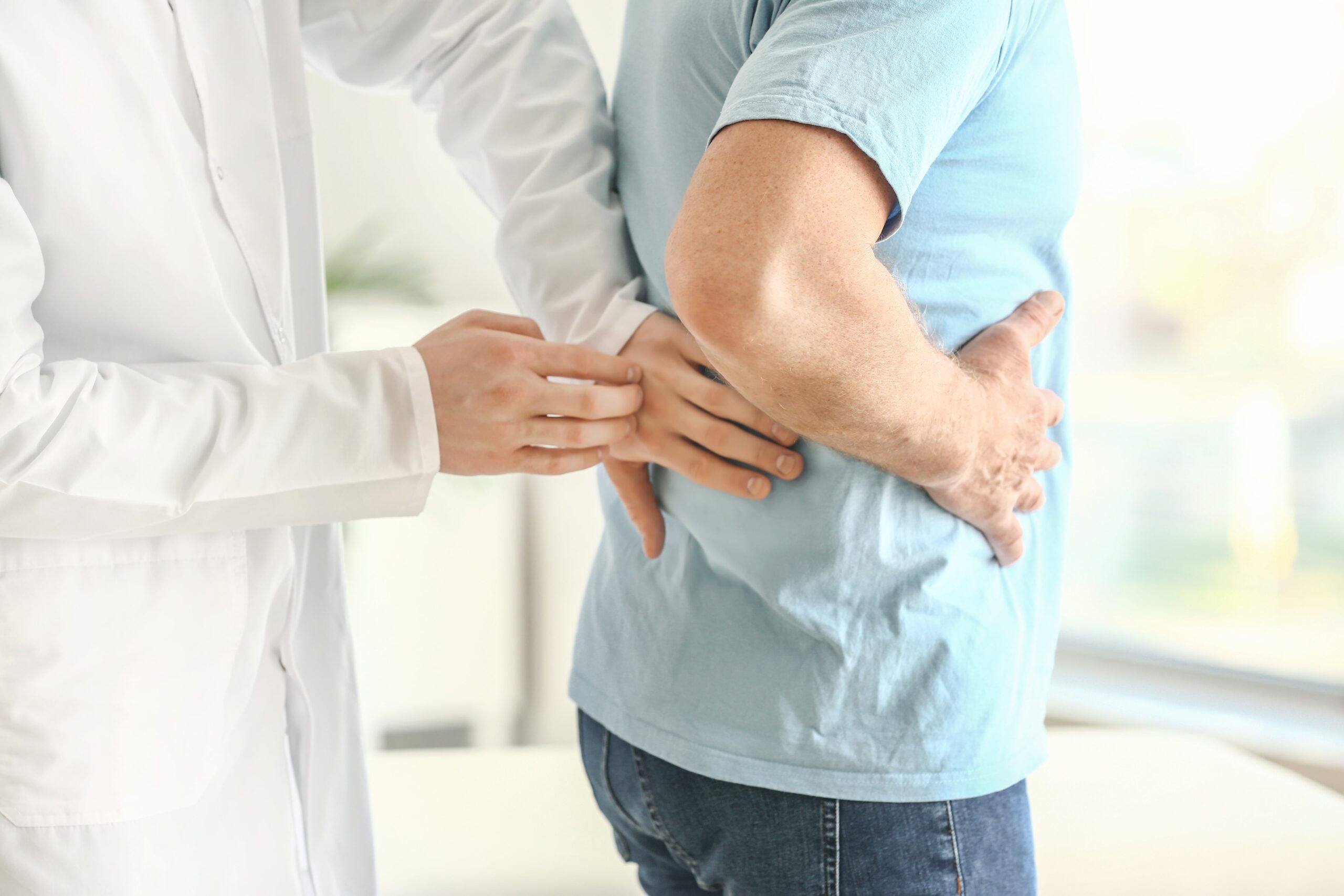 urologist examining patient back due to kidney stone.