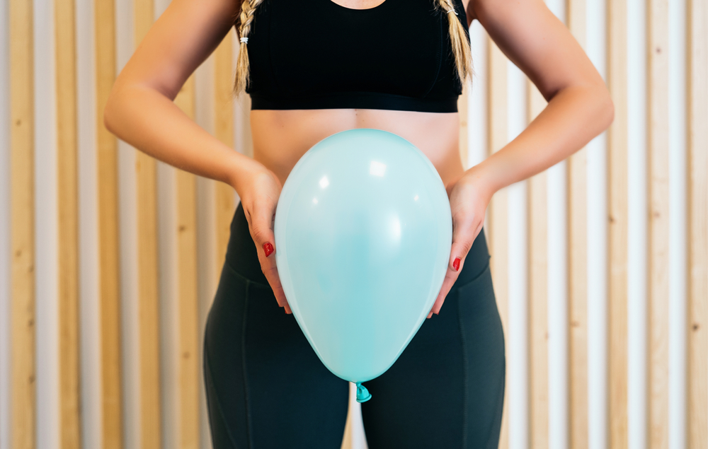 woman holding balloon at hips.